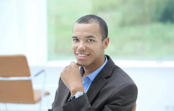 Closeup.portrait de joven empresario de éxito en el fondo de la oficina . — Foto de Stock