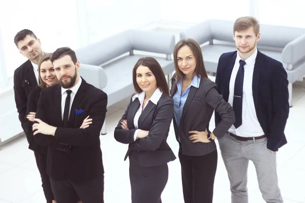 Primer plano. Un grupo de personas de negocios exitosas de pie en el pasillo de oficinas —  Fotos de Stock