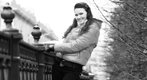 Sonriente joven con chaqueta roja de otoño en un fondo de la ciudad —  Fotos de Stock