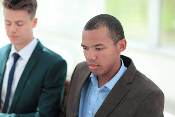 Ung affärsman på bakgrunden av anställde — Stockfoto