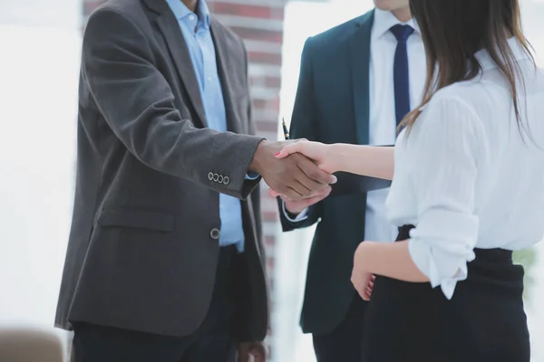 Primer plano .business apretón de manos de los socios financieros en el fondo de la oficina — Foto de Stock