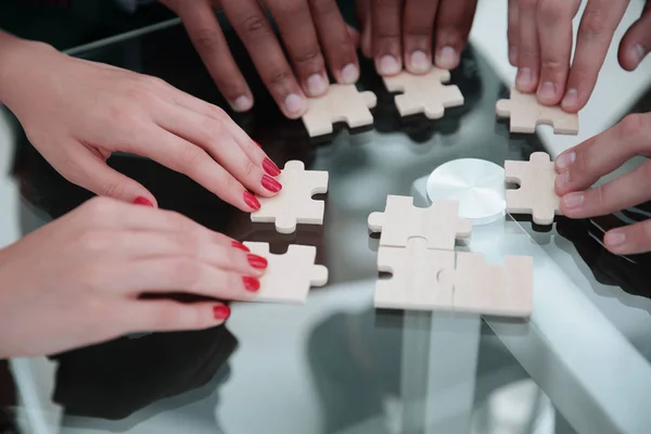 Closeup.business Team Puzzle zusammensetzen, am Tisch sitzen. — Stockfoto