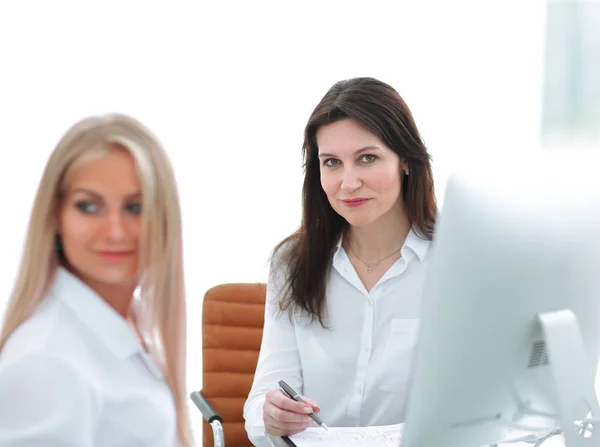 Duas mulheres de negócios sentadas na mesa no escritório . — Fotografia de Stock