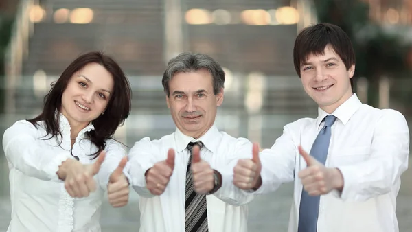 Closeup . successful business team holding up a thumbs up — Stock Photo, Image