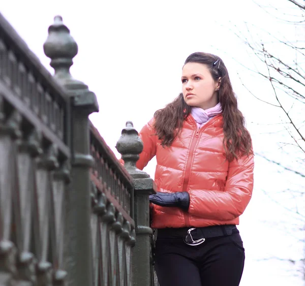 年轻妇女在红色秋天夹克在城市背景 — 图库照片