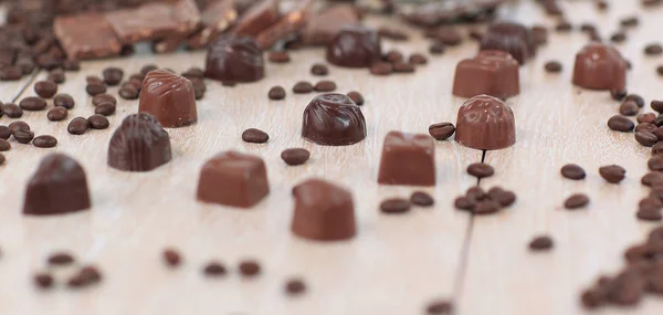 Obrázek pozadí černé kávy obilí a čokoládové cukroví na wo — Stock fotografie