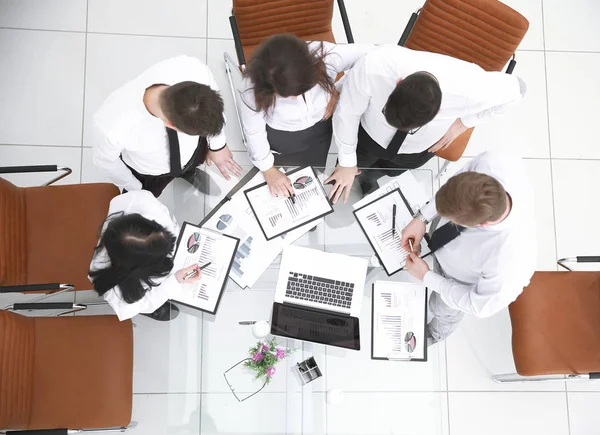 Vista superior. equipo de negocios de pie cerca del escritorio.el concepto de trabajo en equipo — Foto de Stock