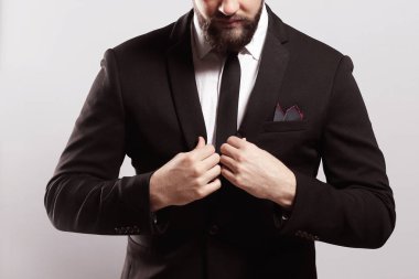 Güven ve karizma. Yakışıklı genç adam tam takım ceketini ayarlama