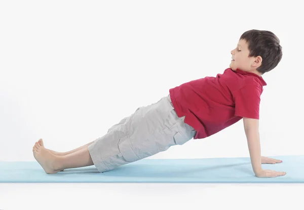 Kleine jongen voert ochtend gezondheid gymnastics.isolated op wit — Stockfoto