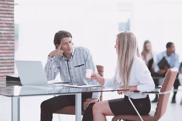 Jóvenes empleados hablando en un escritorio en la oficina — Foto de Stock