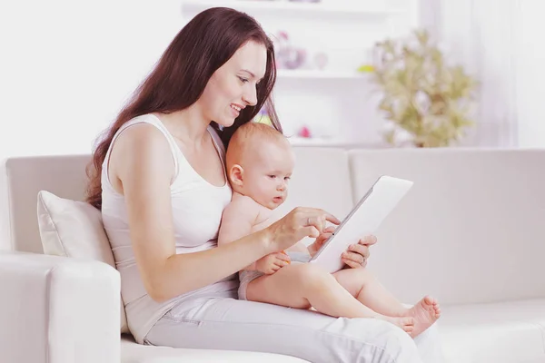 Mother shows the baby pictures on a digital tablet — Stock Photo, Image