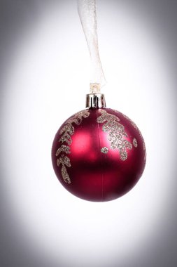 Kırmızı noel topu beyaz arka planda izole edilmiş.