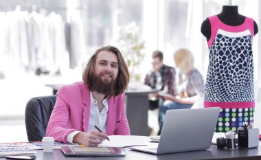 stüdyoda bir masada oturan bir grafik tablet Moda Tasarımcısı kullanır