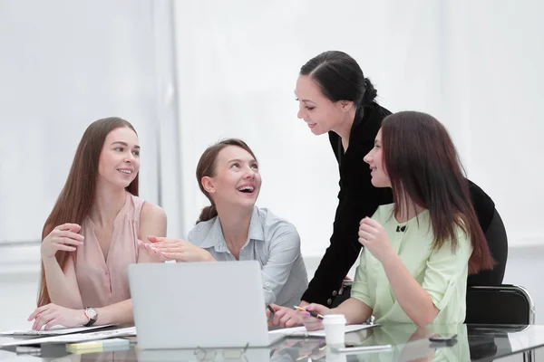 Dipendenti che leggono buone notizie on line in un computer portatile seduto in un desktop in ufficio — Foto Stock