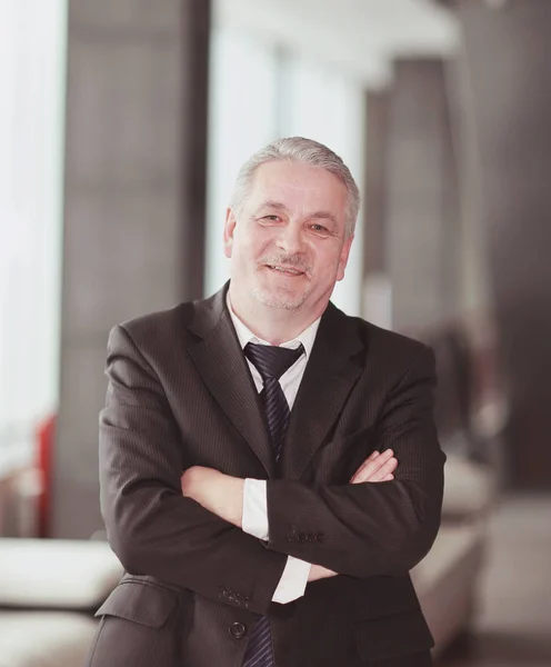 Portrait of an adult businessman on office background — Stock Photo, Image