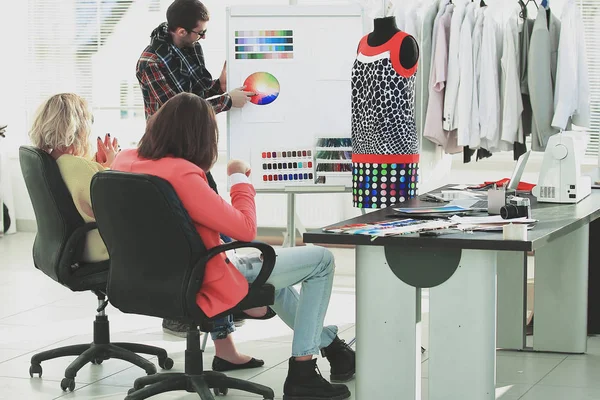 Grupo de designers discutindo uma nova coleção de roupas — Fotografia de Stock