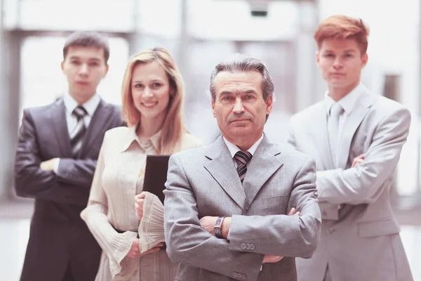 Hombre de negocios y su equipo de negocios en el fondo borrosa oficina — Foto de Stock