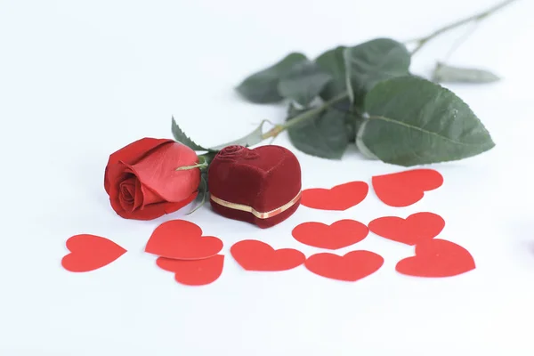 Ring in roter Schachtel mit roter Rose auf weißem Hintergrund — Stockfoto