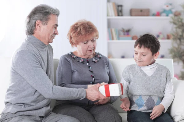 Älteres Ehepaar beschenkt seinen Enkel zum Geburtstag — Stockfoto