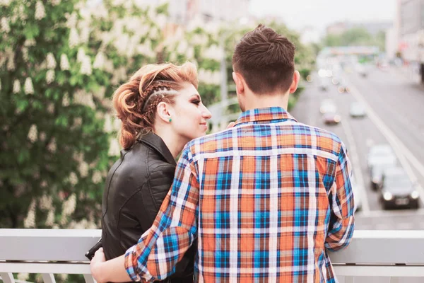 Concepto de amor: joven pareja hermosa de pie en el puente en la gran ciudad — Foto de Stock