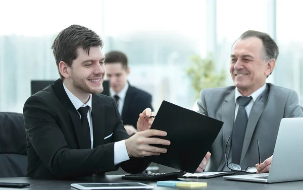 Volwassen zakenman financiële documenten met een jonge collega bespreken. — Stockfoto