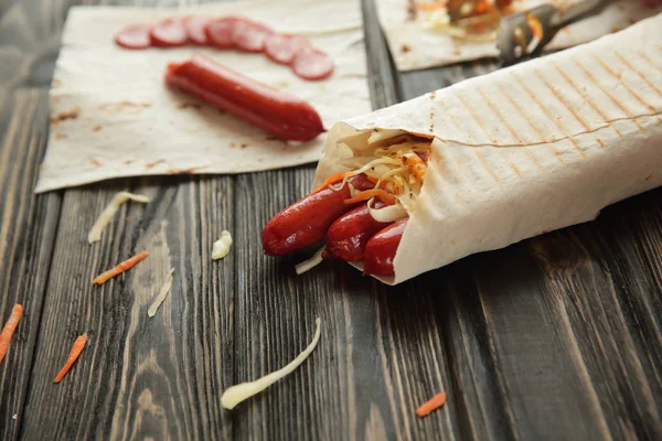 smoked sausage in pita bread on wooden background