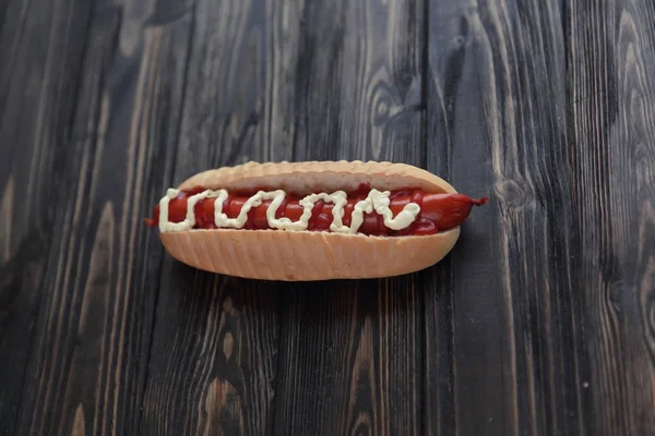 Virsli füstölt kolbásszal és majonéz, fából készült háttér — Stock Fotó