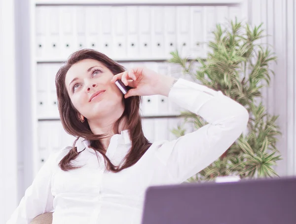 Улыбающаяся деловая женщина разговаривает по телефону на рабочем месте , — стоковое фото