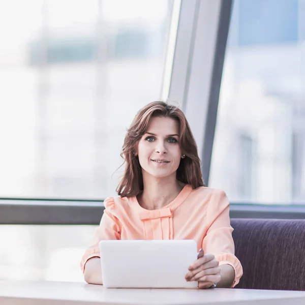 Успешная деловая женщина с планшетом сидит за столом в холле офиса — стоковое фото