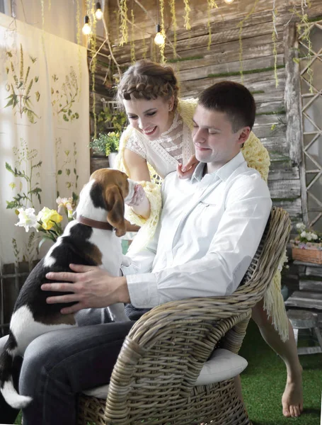 Jeune couple avec animal de compagnie assis sur une chaise — Photo