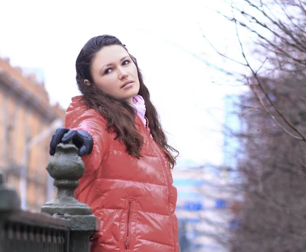 Young woman in red autumn jacket on a background of city — Stock Photo, Image