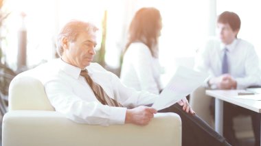 modern bir ofiste oturan bir belge durulması işadamı