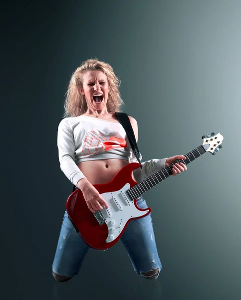 Mooie jonge blonde vrouw met een gitaar zingt een rock lied — Stockfoto