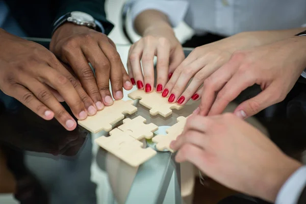 Nahaufnahme. Geschäftsteam mit Puzzleteilen hinter einem Schreibtisch — Stockfoto