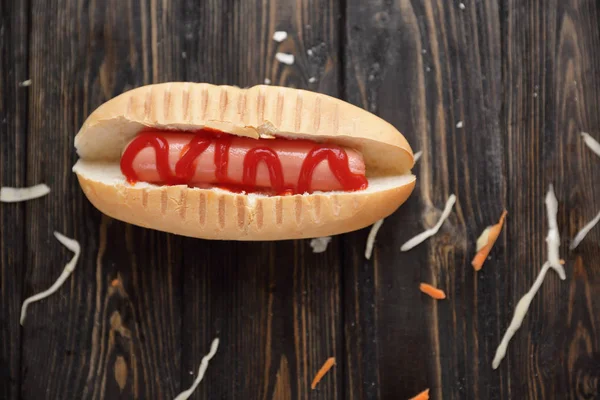 Hot dog a nakládané zelí na tmavé dřevěné background.photo s kopií prostor — Stock fotografie