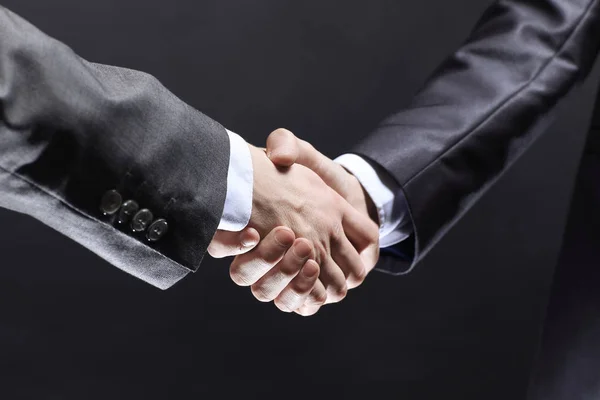 Närbild. handslag för handel partners.isolated på svart bakgrund — Stockfoto