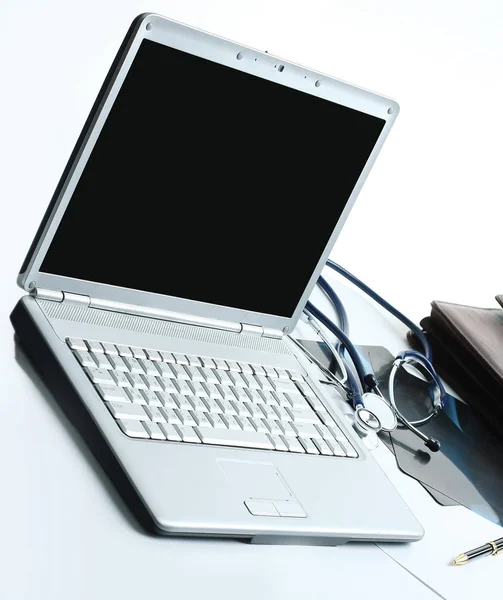 Κινηματογράφηση σε πρώτο πλάνο. laptop και στηθοσκόπιο για τον θεραπευτή στο χώρο εργασίας — Φωτογραφία Αρχείου