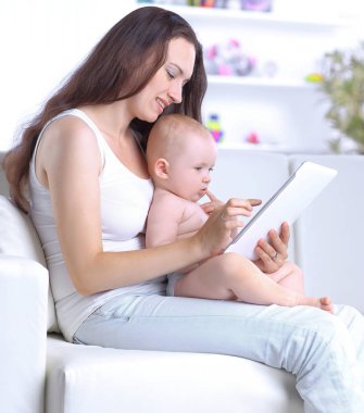 Anne ve bebek dijital tablet ekranına bakıyorlar.