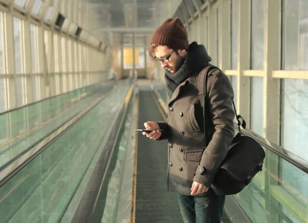 Giovane uomo digitando SMS in piedi nella metropolitana — Foto Stock