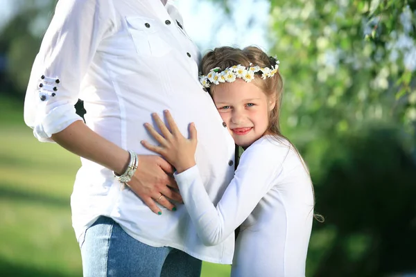 Konzept der Mutterschaft - schwangere Mutter und kleine Tochter auf einem — Stockfoto