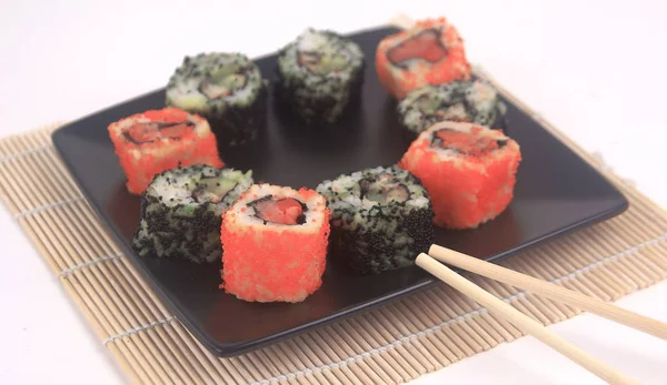 Sushi Set - different types of Maki sushi and chopsticks on a b — Stock Photo, Image