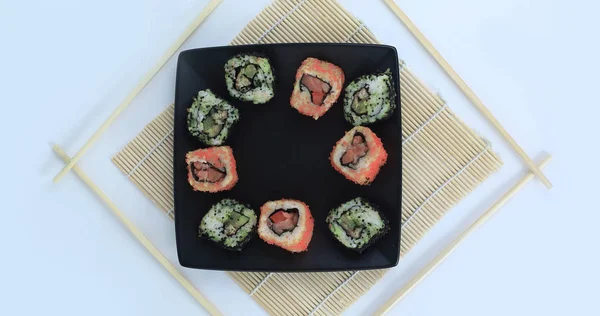 Diferentes tipos de sushi Maki em uma placa preta — Fotografia de Stock