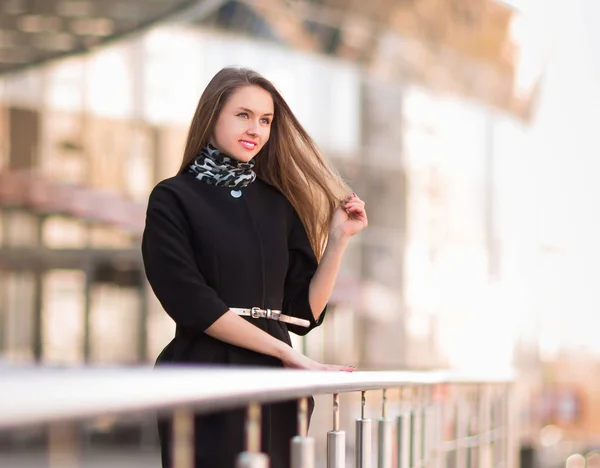 Young female employee of a company is standing near a modern office — Stock Photo, Image