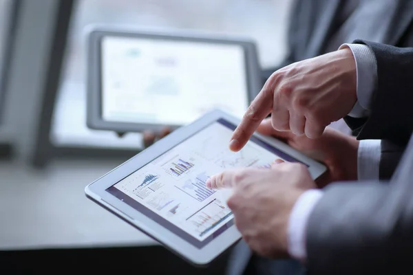 Close up.two hommes d'affaires discutant de données financières à l'aide d'une tablette numérique — Photo