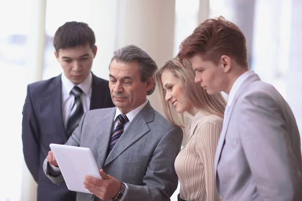 Hombre de negocios y su equipo miran la pantalla de la tableta digital — Foto de Stock