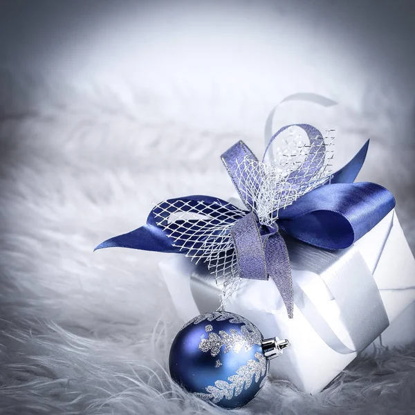 Karácsonyi ajándék és kék karácsonyi golyó egy ünnepi fehér fonákkal — Stock Fotó
