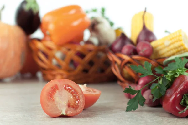 Verduras frescas en cestas de mimbre sobre la mesa de madera . — Foto de Stock