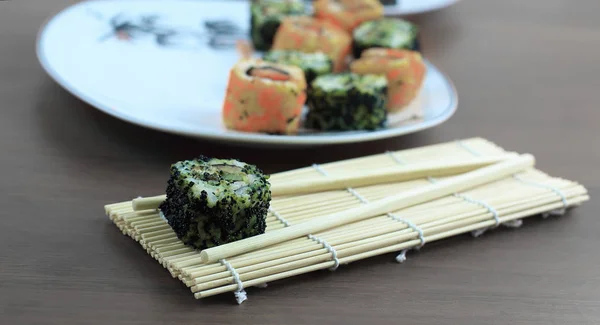 Suşi rulo ve chopsticks ahşap bir masa üzerinde — Stok fotoğraf