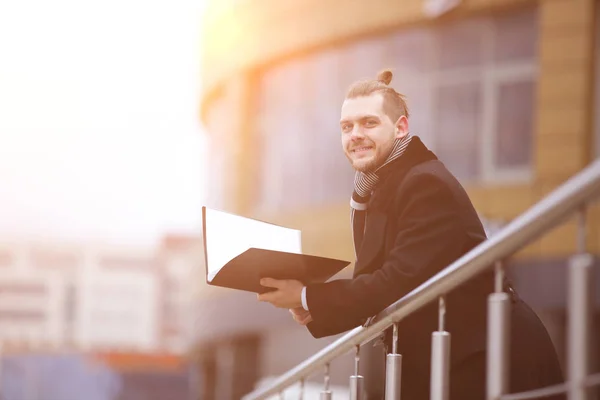 Smiling business man in warm clothes with papers — Stock Photo, Image