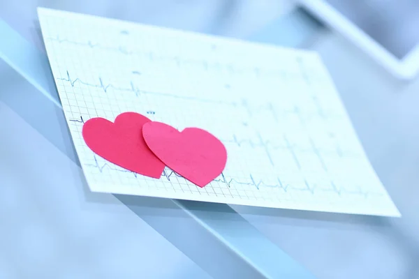 Cardiogram en twee rode papier hart op tafel — Stockfoto